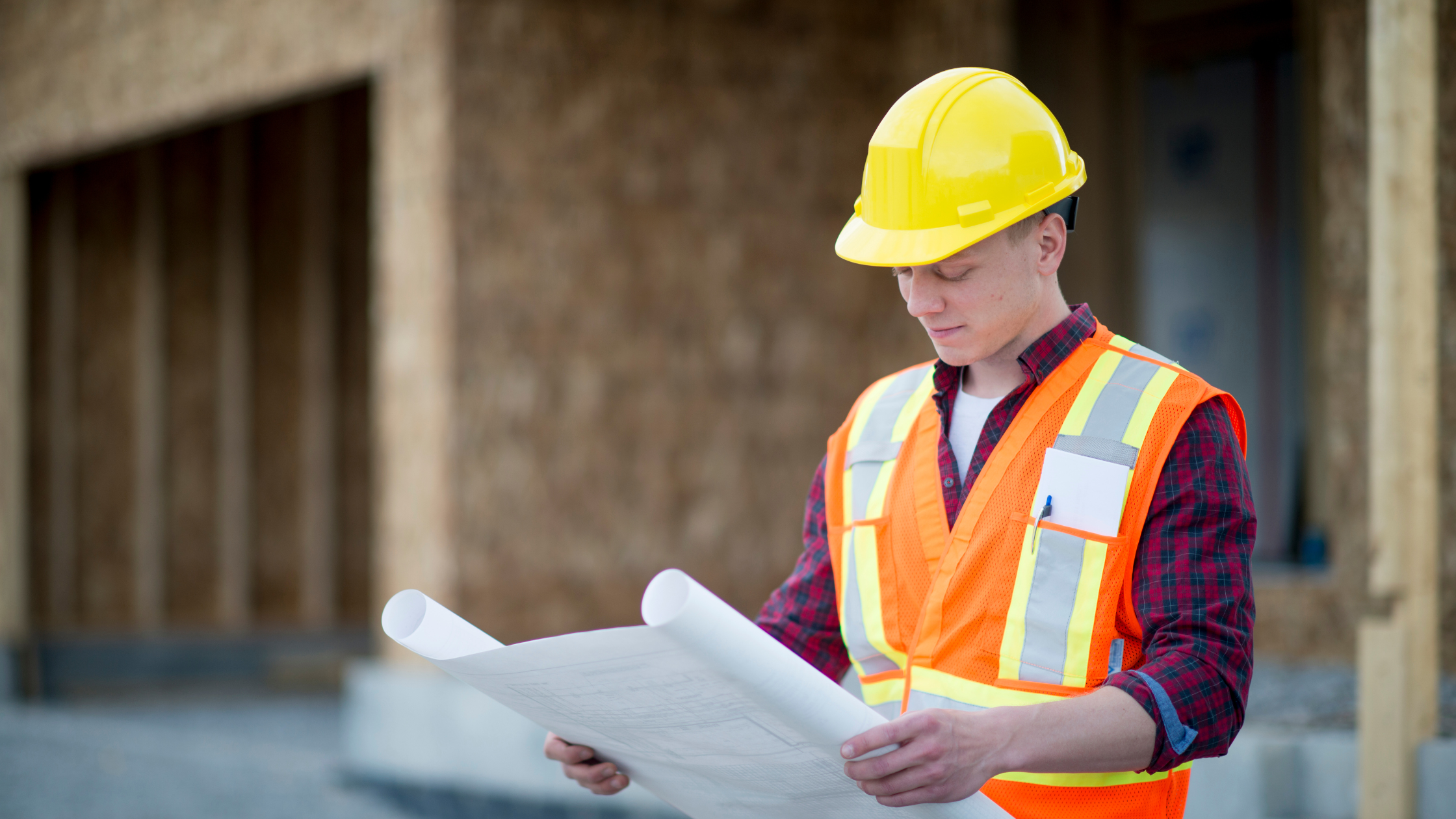 Construction worker looking at building blue prints