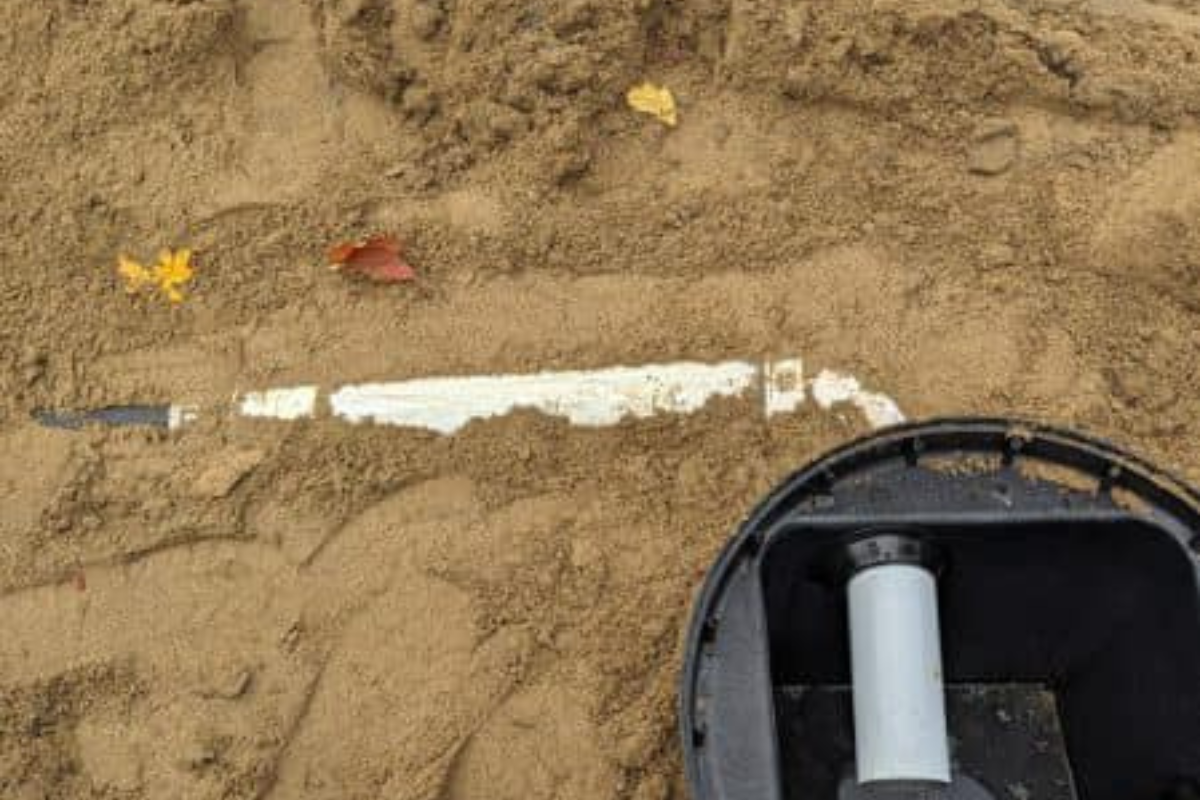 Distribution box and piping connections in place before final cover, ensuring balanced flow to the Eljen system trenches.