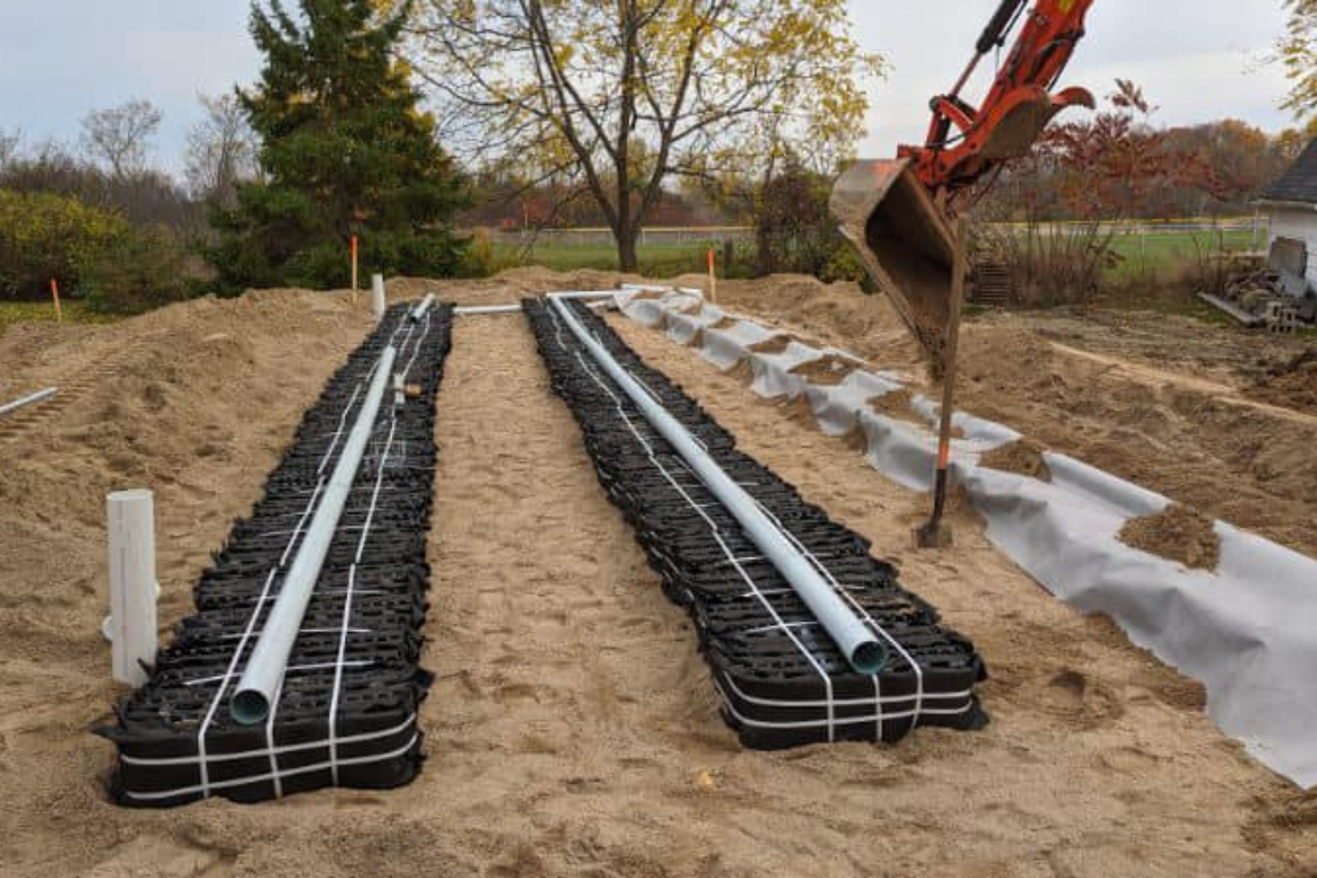 Eljen GSF system components placed and aligned in trenches, with distribution pipes secured and final backfill underway.