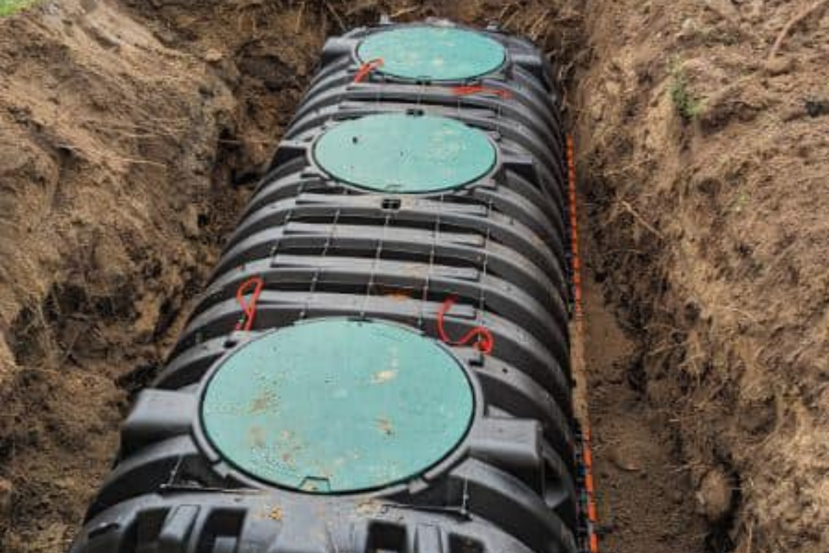Septic tank with risers fully installed in trench, showing secure lid placement and ready for backfill.