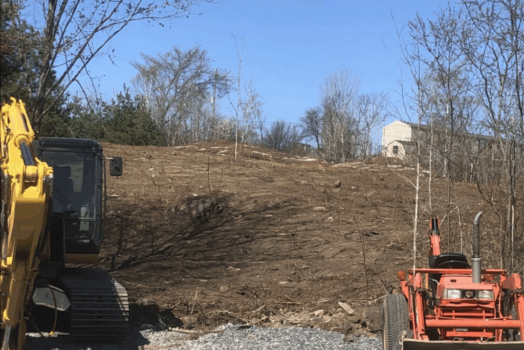 View from the bottom of a graded hill with excavators parked after land clearing.