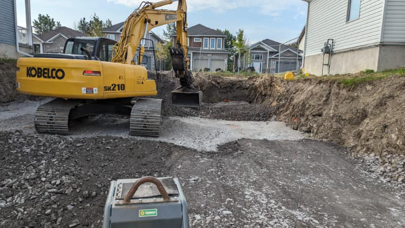 Excavation around foundation to address water intrusion. 