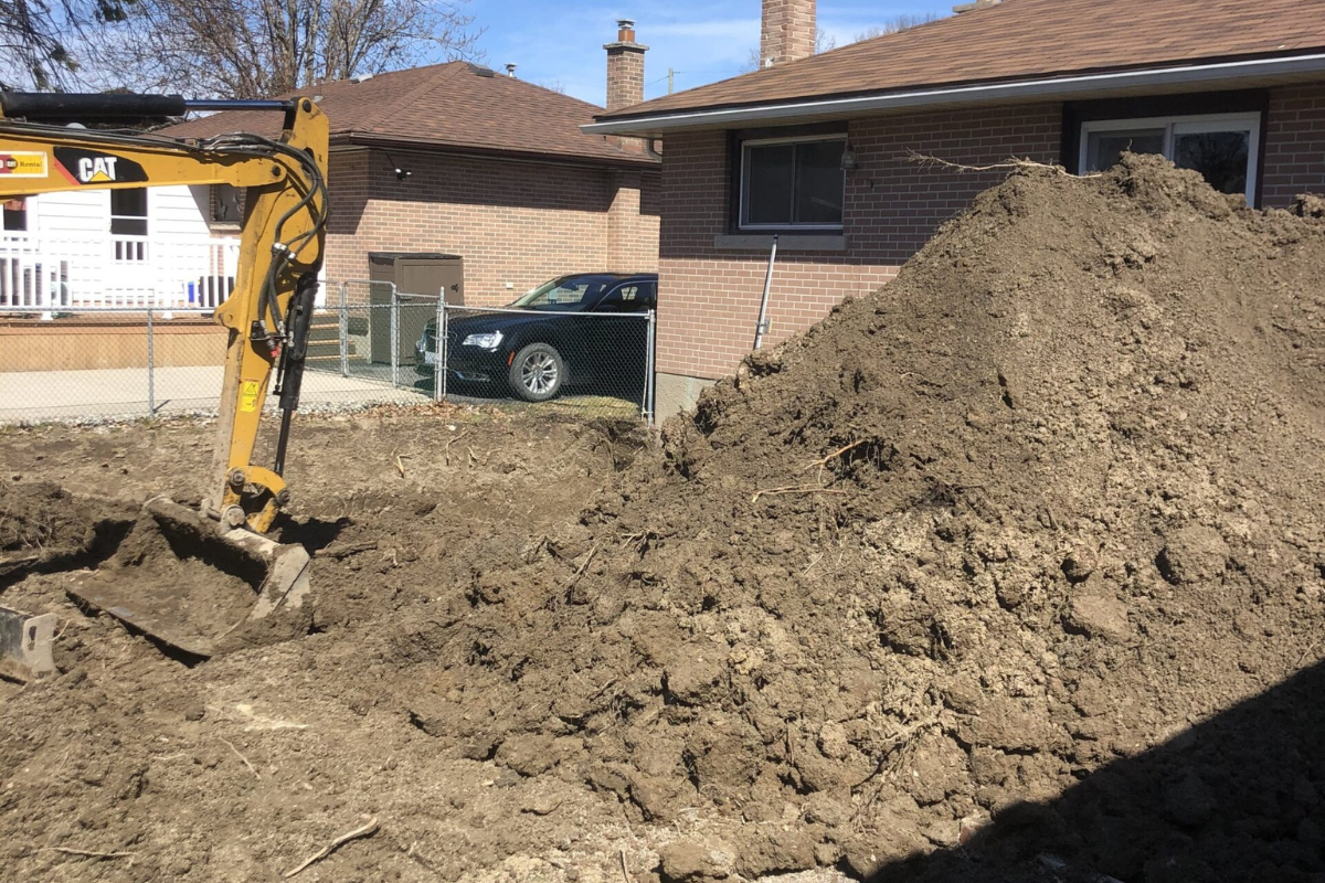 Residential excavation with a pile of soil.