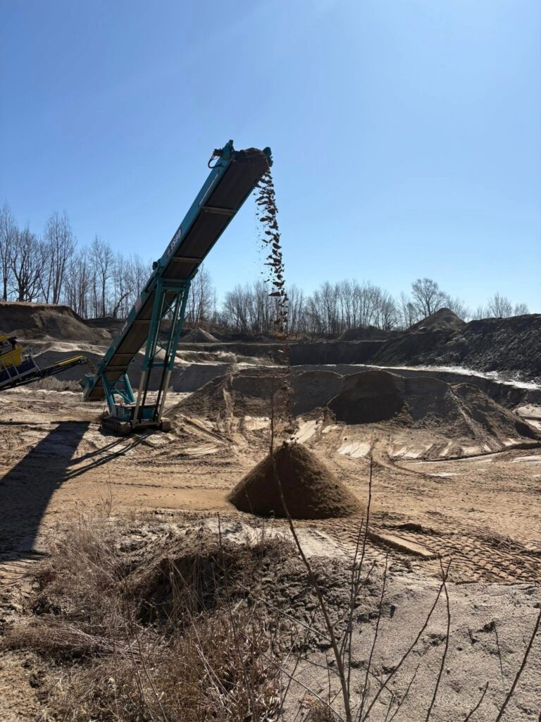 Soil falling from a belt into a pile.