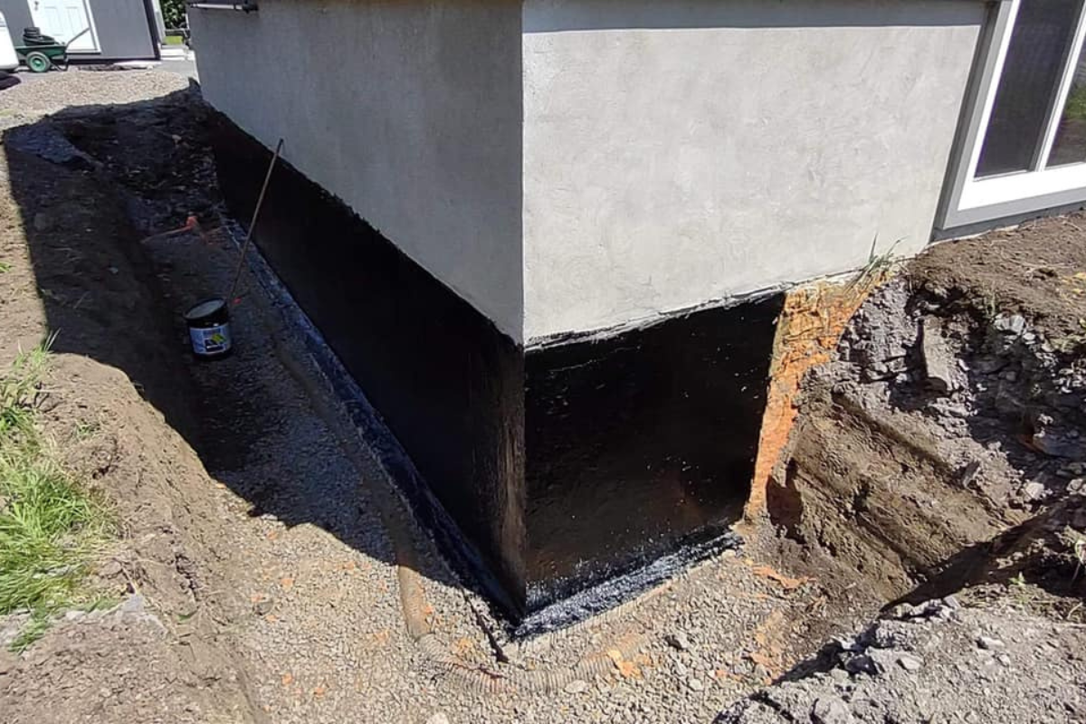 Waterproofing barrier around a cement foundation of a home.