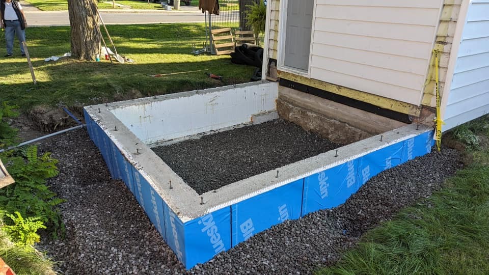 A new foundation for a home extension wrapped in a waterproof membrane.